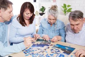 Senior couple solving jigsaw puzzle together with family at home. photo