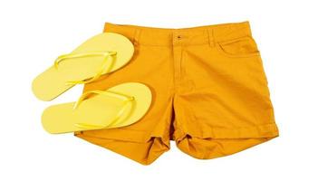 Close up orange shorts and summer slippers isolated on white background photo