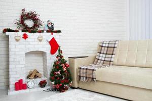sala de estar de navidad con un árbol de navidad y una chimenea presenta debajo de ella - estilo clásico moderno, concepto de año nuevo foto