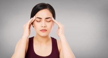 Asian woman's migraine severely, suffering korean,chinese girl isolated on grey background, healh care concept photo