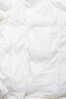 Vista superior del pliegue de las sábanas, textura de manta blanca. Cerca de sábanas con espacio de copia foto