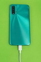 Green cell phone connected to USB cable type C - Charging photo