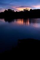hermoso cielo paisaje con puesta de sol sobre la orilla del río foto
