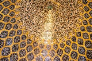 Isfahán, Irán, 2016: hermoso techo interior con bandas ornamentales llenas de patrones arabescos con forma de pavo real en la mezquita sheikh lotfollah foto