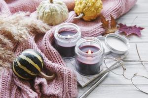 Bodegón de otoño con calabazas y velas encendidas. foto