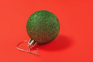 composición navideña en colores verde y rojo. juguete de navidad sobre un fondo rojo. foto