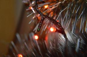 árbol de navidad con juguetes y guirnaldas luminosas en casa y en el fondo de la oficina