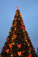 La tarde y la noche el árbol de navidad brilla con luces en la ciudad en invierno borrosa foto