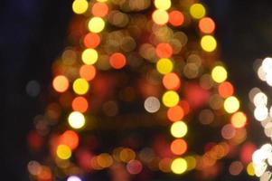 Evening and night Christmas tree glows with lights in the city in winter blurred photo