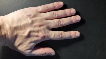Hand of a man in various states on a black background photo