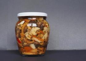 mixed champignons and porcini mushrooms in jar photo