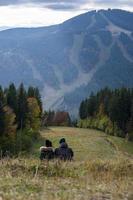 Couple of lovers sitting on the mountainside photo