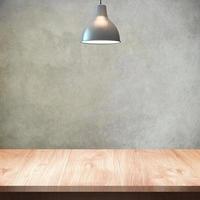 mesa de madera con lámpara y fondo de pared foto