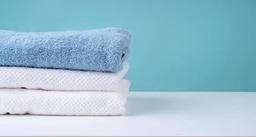 Pila de toallas limpias sobre fondo azul. foto