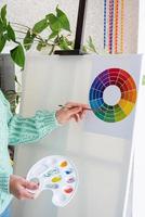 Young teenage woman artist holding color palette working in her studio photo