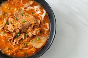 Korean udon ramen noodles with pork in kimchi soup photo