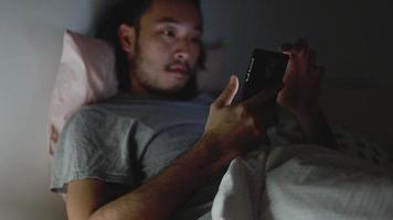 Young Asian men using a smartphone browsing web and scroll through social media feed on mobile phones. video