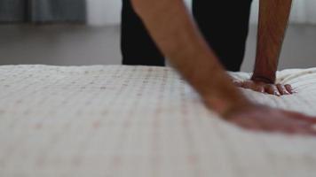 Hands touch bedspread arranges cushions in the bedroom. video