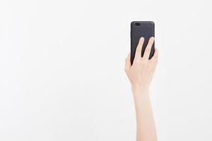 Hand holding black phone isolated on white clipping path inside. Top view.Mock up.Copy space.Template.Blank. photo