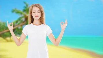 Sonrisa mujer con los ojos cerrados en pose de meditación zen en la playa tropical océano mar fondo - concepto de yoga de verano, espacio de copia foto