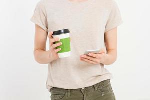 Girl holding white phone and coffe. Cellphone isolated on white clipping path inside. Top view.Mock up.Copy space.Template.Blank. photo