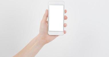 Asimiento de la mano femenina teléfono móvil aislado en blanco, mujer sosteniendo el teléfono con pantalla vacía, pantalla en blanco, tocando foto
