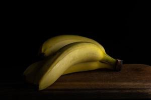 several bananas on a wooden board photo