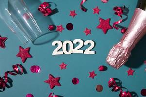 feliz navidad 2022 año nuevo plano con champán, copa y estrellas, serpentinas foto