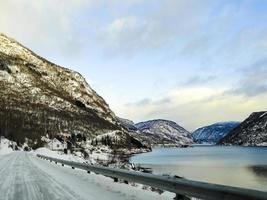 Driving at sunrise by the fjord on black ice, Norway. photo