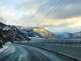 Driving at sunrise by the fjord on black ice, Norway. photo