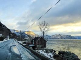 Driving at sunrise by the fjord on black ice, Norway. photo