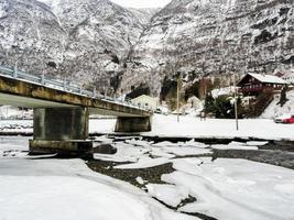 Winter landscape frozen river lake fjord, ice banks bridge, Norway. photo