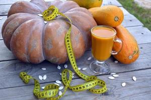 Diet vegetable juice. Huge pumpkin and zucchini on a wooden background. photo