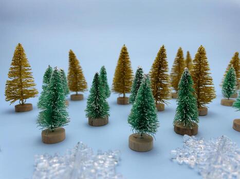 Snowflakes, golden and green colored pine trees on blue background photo