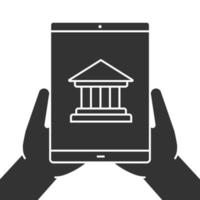 Hands holding tablet computer glyph icon. Internet banking. Silhouette symbol. Tablet computer with bank building. Negative space. Vector isolated illustration