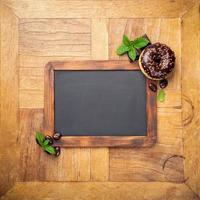 Black chalkboard with chocolate glazed donut photo