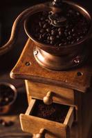 Old wooden coffee grinder with beans photo