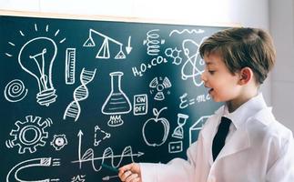 Side view of boy showing drawing on chalkboard photo