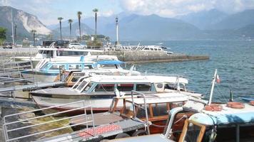 Barcos esperando en el terraplén, navegación en el lago Lago Maggiore en Italia verano