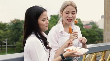 Asian lesbian couples enjoy traveling in Thailand and eating meatballs having fun during vacation time. video