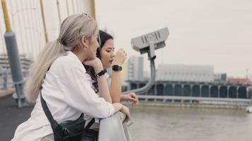 Asian lesbian couples enjoy traveling and talking while standing on the bridge. video