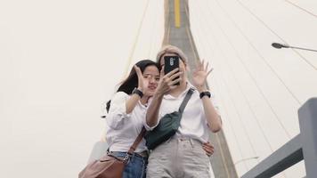 parejas de lesbianas asiáticas autofoto chat de video con amigos que disfrutan de viajar en Tailandia.