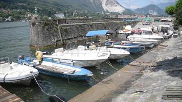 Barcos esperando en el terraplén, navegación en el lago Lago Maggiore en Italia verano