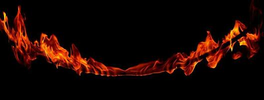 On fire flames at the black background, Burning red hot sparks rise, Fiery orange glowing flying particles photo