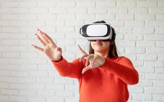 Sonrisa mujer feliz obteniendo experiencia usando gafas vr-headset de realidad virtual en casa muchas manos gesticulantes foto