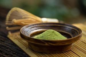 Matcha Powder and dried leaves placed on a natural background. photo