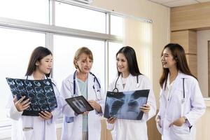 doctor senior mujer enseñando doctor estudiante mujer. cómo analizar la película de rayos X. Departamento de radiología foto