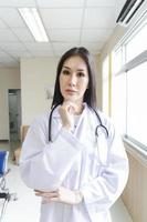 Retrato de una doctora inteligente con un estetoscopio de pie en la recepción del hospital. foto