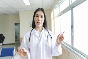 Retrato de una doctora inteligente con un estetoscopio de pie en la recepción del hospital.