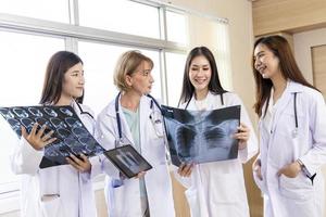 doctor senior mujer enseñando doctor estudiante mujer. cómo analizar la película de rayos X. Departamento de radiología foto